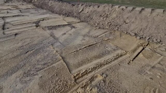  archaeological excavation or construction site where extensive earthworks have been carried out. exposed area with visible which is typical for archaeological surveys. pile of excavated soil, survey 