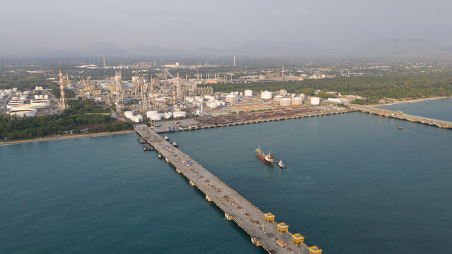 Aerial view of the Map Ta Phut industrial estate featuring energy terminal facilities, storage tanks, and a long pier extending into the sea Map Ta Phut Energy terminal, Rayong, Thailand.