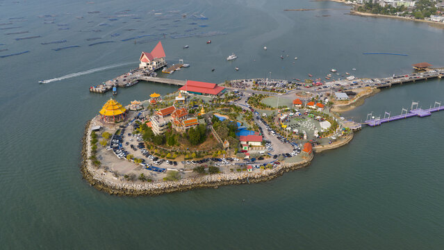 Aerial view of Wat Ko Loi temple complex on Ko Loi island featuring a pier and bridge in Si Racha, Chon Buri, Thailand.