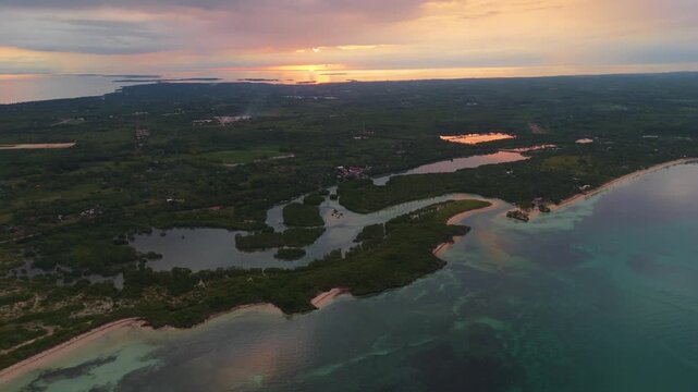 aerial drone of Bantayan Island lagoon , golden sunset over the turquoise waters, white sand beach, and lush mangroves of