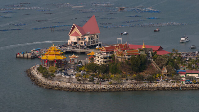 Aerial view of the colorful San Jao Phaw Khao Yai shrine with its yellow pagoda and red-roofed buildings on the coast of Koh Sichang, Chon Buri, Thailand.