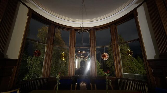 Timelapse of a birthday decorated living room with bay window and hanging garlands as night slowly turns to morning. Home celebration scene with anticipation, quiet waiting and early daylight.