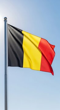 Belgian flag waving proudly against a bright blue sky.