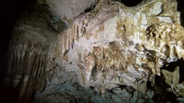 Detailed view of calcite stalactites hanging from ceiling inside cenote cavern in Cenote Dos Ojos, Quintana Roo, Mexico