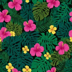 Fototapeta premium Lush Tropical Foliage and Vibrant Hibiscus Blossoms in a Vivid Jungle Setting