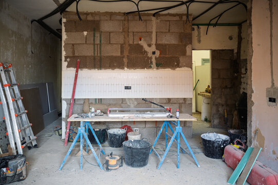 Construction site interior renovation with tools, unfinished brick wall and workbench
