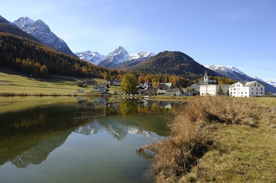 Taraspersee Lake with a reflection in front of the village of Tarasp, Scuol, Lower Engadin, Grisons, Switzerland, Europe