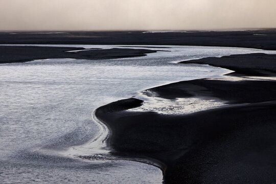 Glacial runoff permeate the volcanic sand plain Skeidararsandur, Backlit, Southern Region, Iceland