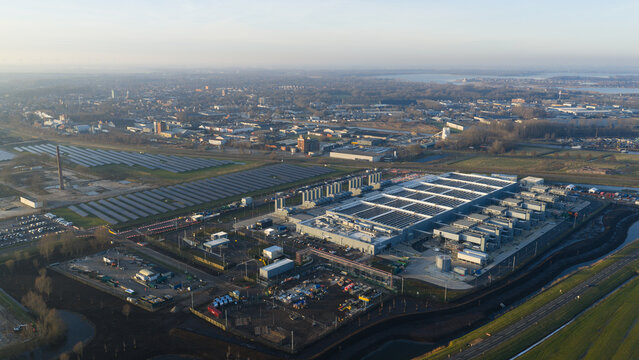 Aerial view of the Datacenter Winschoten facility featuring large solar panel arrays and industrial infrastructure surrounded by fields and the town skyline in Winschoten, Groningen, Netherlands.