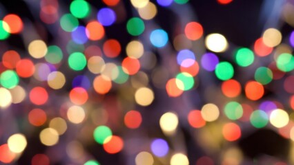 Fototapeta premium Multicolored bokeh lights scattered across dark festive background