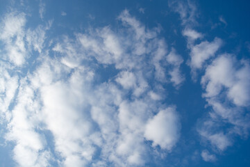 Obraz premium Blue sky with scattered fluffy white clouds, natural cloudscape background with copy space, calm weather concept, minimal outdoor scene.