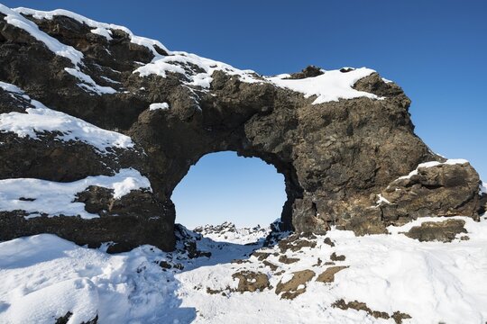 Natural arch, view of a snowy landscape, lava field covered with snow, Krafla volcanic system, Dimmuborgir National Park, M&yacute;vatn, Iceland
