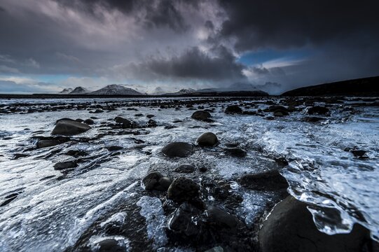 Frozen Seljalands&aacute; river with dramatic cloudy sky, Vik, Iceland