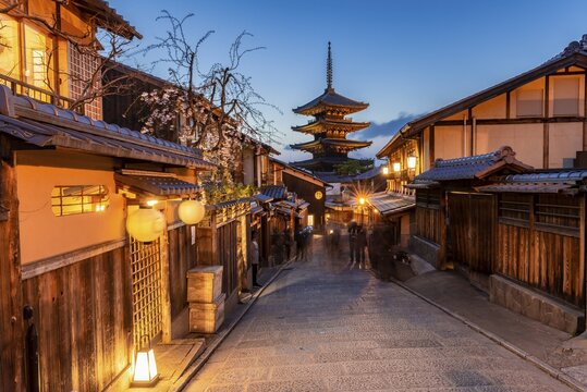 Pedestrian in an alleyway, Yasaka dori historical alleyway in the old town with traditional Japanese houses, rear five-storey Yasaka pagoda of the Buddhist Hōkanji temple, evening mood, Kyoto, Japan