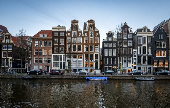 Historic row of houses on a canal at dusk, Amsterdam, North Holland, Netherlands
