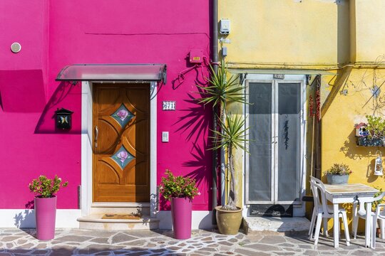 Two colorful houses, plants and table, colorful facade, Burano Island, Venice, Veneto, Italy