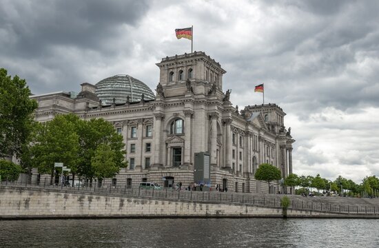 Reichstag building with waving German flag on the Spree, government quarter, Berlin, Germany