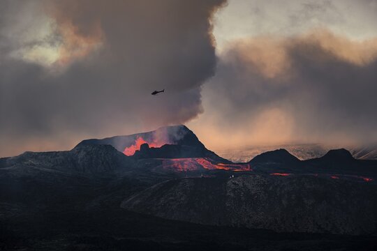 Helicopter flying over nus erupting volcano with lava fountains and lava field, crater with erupting lava and lava flow, Fagradalsfjall, Kr&yacute;suv&iacute;k volcano system, Reykjanes Peninsula, Iceland
