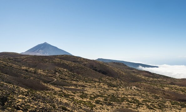 Road leading through a volcanic landscape with Pico del Teide, 3718m, Parque Nacional de las Ca&ntilde;adas del Teide, Teide National Park, UNESCO World Heritage Site, Tenerife, Canary Islands, Spain