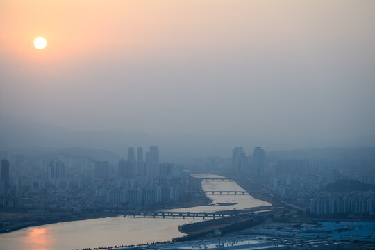 Sunset Over Ulsan City Skyline with Smog and Sun Fading into Haze