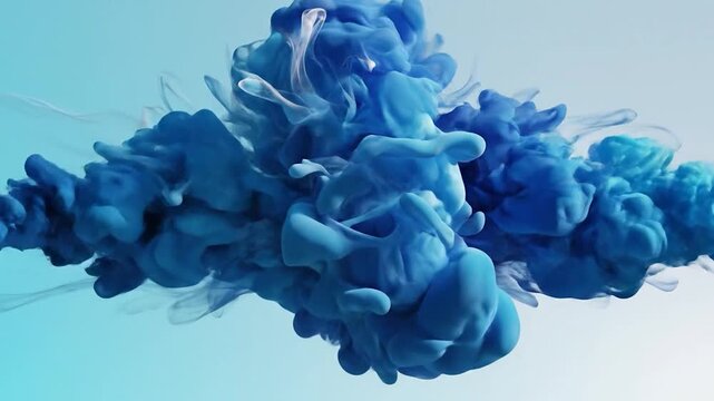Abstract swirling clouds of blue and light blue ink dissolving in clear liquid creating dynamic fluid motion