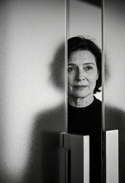 Minimalistisches Schwarz-Wei&szlig;-Portr&auml;t einer Frau hinter einer Milchglast&uuml;r