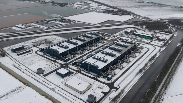 Aerial view of Agriport a7 datacenter with snow-covered roofs and industrial infrastructure in Middenmeer, Noord-Holland, Netherlands.