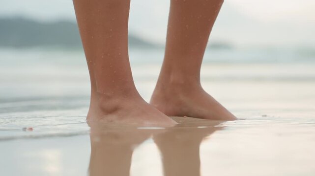 Energetic footsteps on sunny shoreline sands. Footloose dancer celebrates freedom on vibrant coastal terrain. Carefree traveler sprints barefoot along lively and sandy seaside coastlines