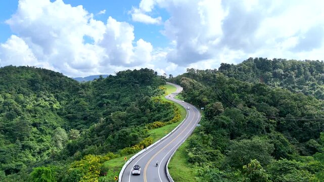 Aerial view of car driving on beautiful steep curved road (look like number 3) on the high mountain in Nan province, Thailand.