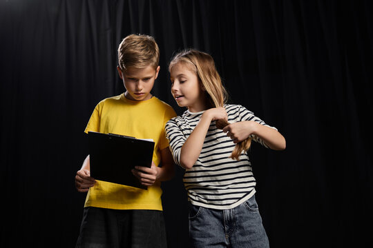 Excited young actors rehearsing their lines under the bright lights of the theater stage