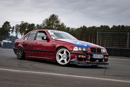 Riga, Latvia 2026-03-28  Red sports sedan racing on a paved track with smoke
