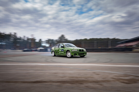 Riga, Latvia 2026-03-28  Green sports car racing on a track with blurred motion