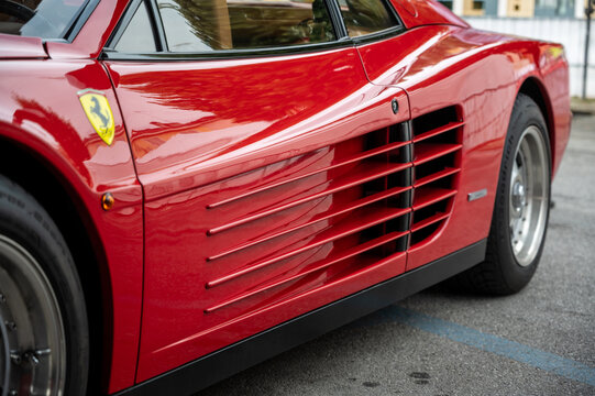 Mondov&igrave; (cuneo), italy, july 21, 2024. Ferrari rally. Red ferrari testarossa sports car parked outdoor, highlighting its distinctive side strakes and giallo modena scuderia shield