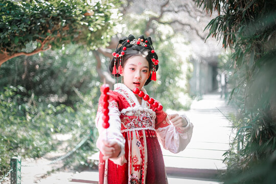 The girl in hanfu holds Tomatoes on sticks