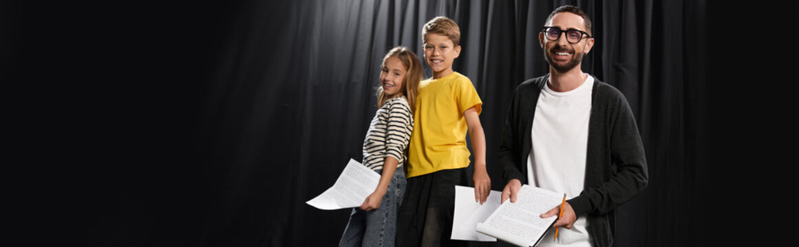 Stylish male tutor guides children in the art of theater performance and creativity