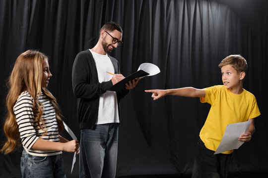 Stylish male tutor guides young students in an engaging theater class
