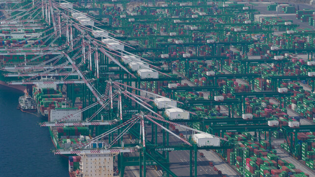 Fengsen Village, Taiwan - 26 February 2026: Aerial view of the Port of Kaohsiung featuring rows of green gantry cranes and stacks of shipping containers at the Evergreen terminal.