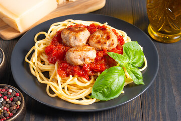 Fototapeta premium Delicious spaghetti with tasty meatballs in tomato sauce, and basil on background. Restaurant menu.