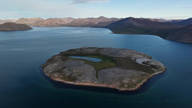 Remote island lagoon in Penkigney Bay near Provideniya, Chukotka. The drone pans right keeping the tundra shore in view. Summer evening light reveals vast northern wilderness
