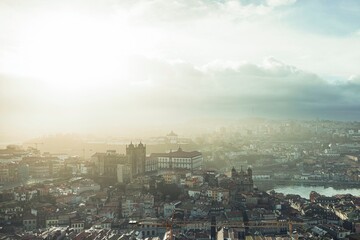 Naklejka premium Porto's skyline shimmers under a distant sun, revealing a blend of modern and historic architecture. Digital nomads navigate life amidst evolving housing prices and economic pressure