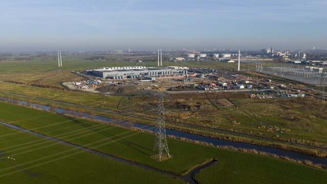 Groningen, Netherlands - 20 January 2026: Aerial view of Datacenter Westpoort under construction with high-voltage power lines and green fields in Groningen, Netherlands.