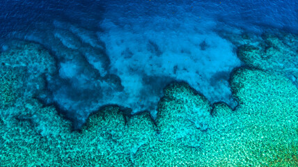 Top down aerial of coral reef and deep blue ocean contrast © Rory