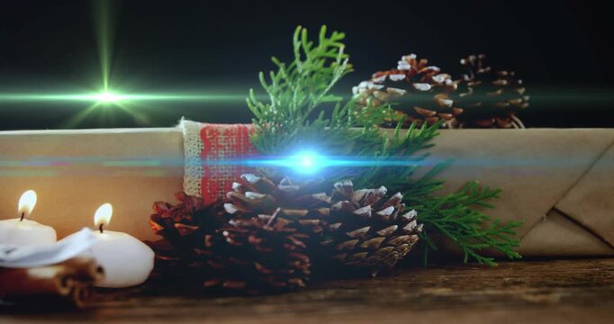 Hand nudging cone, candles lighting and lens flares sweeping across holiday gift creating mood