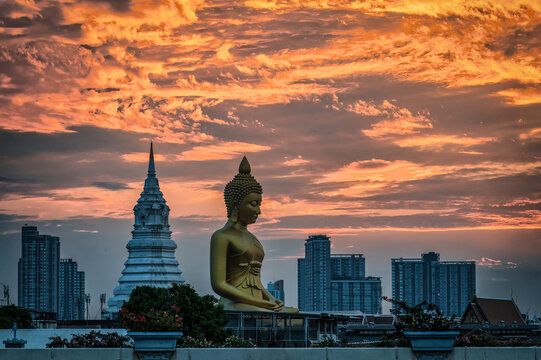 Panoramic sunset view of massive golden Buddha statue and white pagoda Wat Paknam over Bangkok