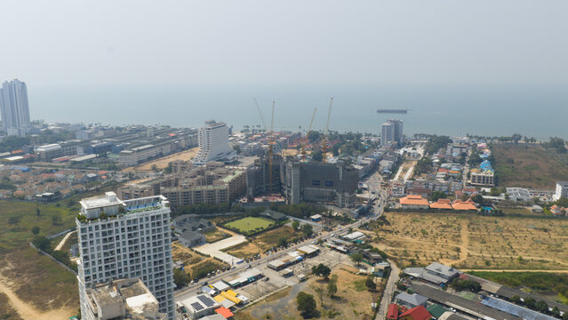 Copacabana, Thailand - 10 February 2026: Aerial view of Copacabana Coral Reef residential building construction site with cranes against the vast, pale blue ocean backdrop.