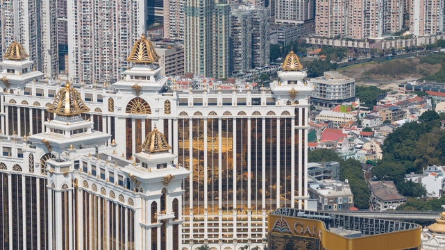 Taipa, Macao - 18 February 2026: Aerial view of the golden grandeur of the Galaxy Macau casino against the backdrop of densely packed residential towers.