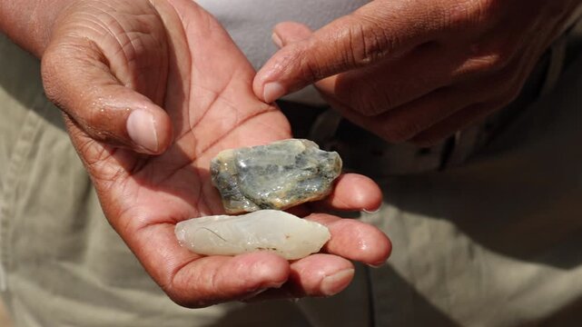 Close-up of Hand Holding Rough Uncut Gemstones and Pointing with a Finger, Revealing Natural Beauty and Potential Value. Sri Lanka island, Asia.