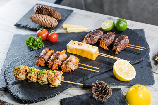 Assorted izakaya skewers with lemon and tomato