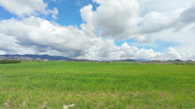 driving on rural road through fields in early spring