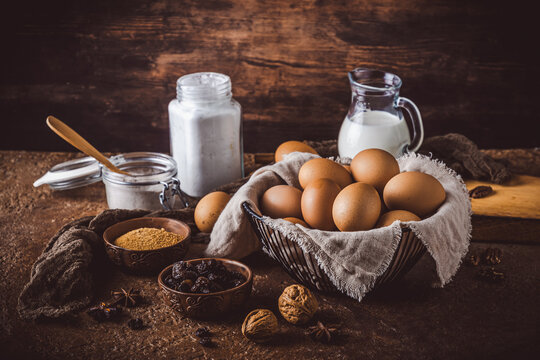 Variety of baking ingredients on rustic bronw table